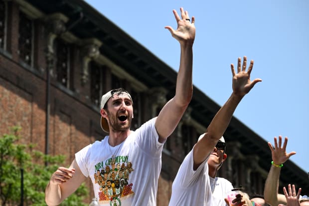 Boston Celtics center Luke Kornet waves to the crowd during the team's 2024 NBA Championship parade.
