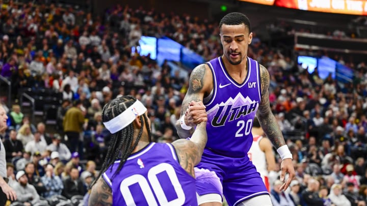 Mar 4, 2024; Salt Lake City, Utah, USA; Utah Jazz forward/center John Collins (20) helps guard Jordan Clarkson (00) off the ground against the Washington Wizards during the second half at the Delta Center. Mandatory Credit: Christopher Creveling-USA TODAY Sports