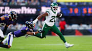 Nov 23, 2025; Baltimore, Maryland, USA;  New York Jets running back Breece Hall (20) rushes as Baltimore Ravens cornerback Nate Wiggins (2) defends during the fourth quarter at M&T Bank Stadium. Mandatory Credit: Peter Casey-Imagn Images