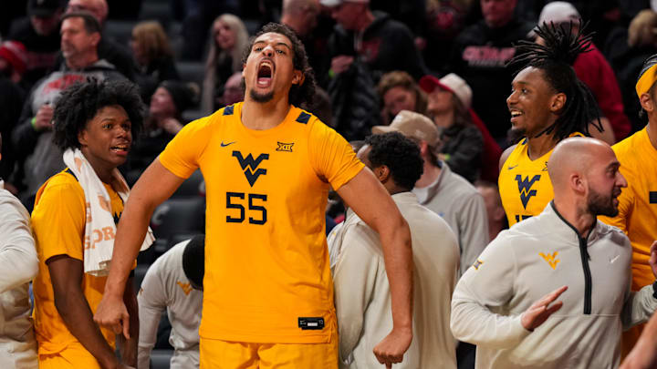 Feb 5, 2026; Cincinnati, Ohio, USA;  West Virginia Mountaineers center Harlan Obioha (55) and teammates react from the bench against the Cincinnati Bearcats in the second half at Fifth Third Arena. Mandatory Credit: Aaron Doster-Imagn Images