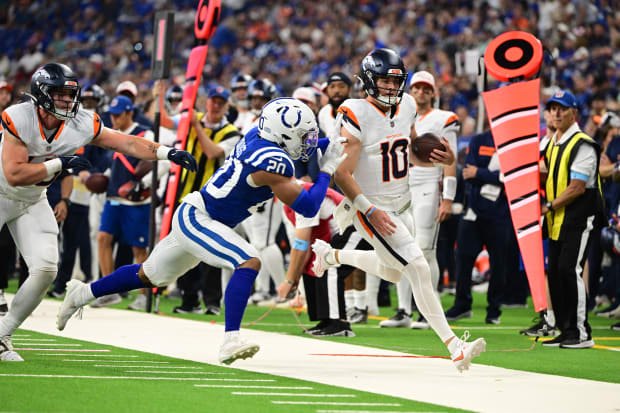 Football player Nick Cross pushes Bo Nix out of bounds in a blue jersey.