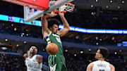 Mar 5, 2025; Milwaukee, Wisconsin, USA; Milwaukee Bucks center Jericho Sims (00) dunks a basket against Dallas Mavericks guard Brandon Williams (10) and center Dwight Powell (7) in the second quarter at Fiserv Forum. Mandatory Credit: Benny Sieu-Imagn Images