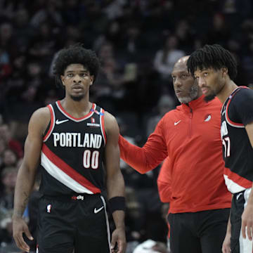 Jan 14, 2025; Portland, Oregon, USA; Portland Trail Blazers head coach Chauncey Billups talks to Scoot Henderson (00) and Shaedon Sharpe (17) during the first half against the Brooklyn Nets at Moda Center. Mandatory Credit: Soobum Im-Imagn Images