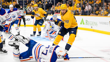 Oct 31, 2024; Nashville, Tennessee, USA; Nashville Predators center Ryan O'Reilly (90) checks Edmonton Oilers defenseman Brett Kulak (27)  during the first period at Bridgestone Arena. Mandatory Credit: Steve Roberts-Imagn Images