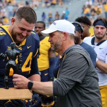 West Virginia offensive lineman Wyatt Milum receives the Iron Mountaineer award from strength and conditioning coach Mike Joseph