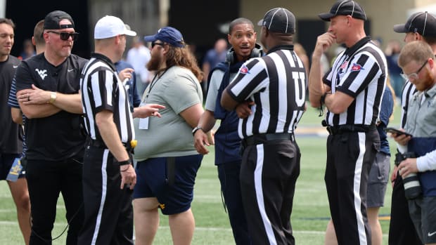 Former West Virginia quarterback Pat White holds a conversation with the officials while former specialist Pat McAfee looks on during the 2024 Gold-Blue Spring Game.