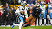 Nov 2, 2025; Green Bay, Wisconsin, USA;  Carolina Panthers quarterback Bryce Young (9) is chased by Green Bay Packers defensive end Micah Parsons (1) during the game at Lambeau Field. Mandatory Credit: Jeff Hanisch-Imagn Images