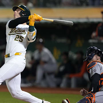 Sep 6, 2024; Oakland, California, USA; Oakland Athletics designated hitter Brent Rooker (25) hits an RBI sacrifice fly against the Detroit Tigers during the twelfth inning at Oakland-Alameda County Coliseum. Mandatory Credit: Darren Yamashita-Imagn Images