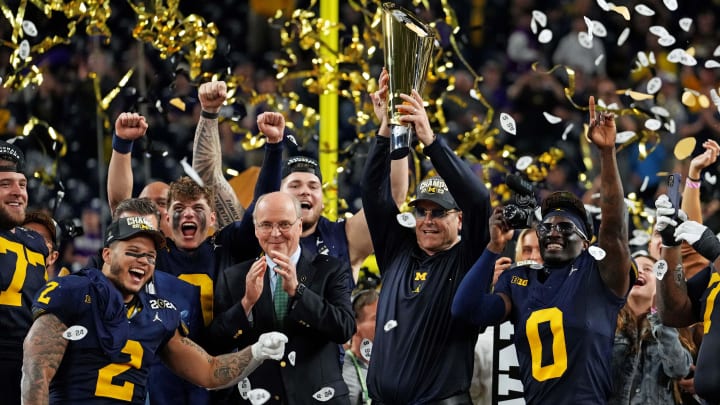 Jan 8, 2024; Houston, TX, USA; Michigan Wolverines head coach Jim Harbaugh celebrates with the CFP Championship trophy after beating the Washington Huskies in the 2024 College Football Playoff national championship game at NRG Stadium.