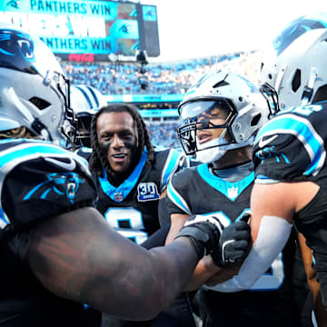 Carolina Panthers RB Chuba Hubbard celebrates with G Damien Lewis, CB Jaycee Horn, and TE Tommy Tremble