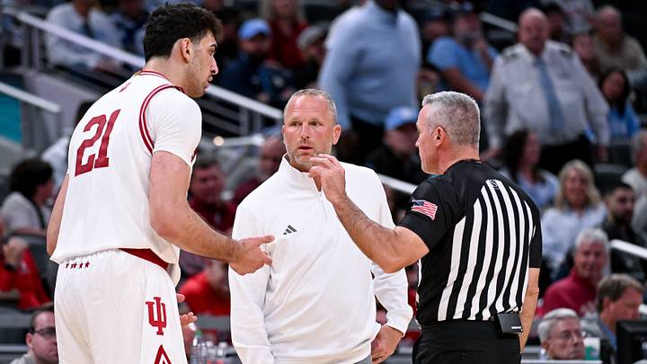 Oct 18, 2026; Indianapolis, IN, USA; Indiana Hoosiers center Samet Yigitoglu (21) and Indiana Hoosiers head coach Darian DeVries talk to a referee against the North Carolina Tar Heels during the second half at Gainbridge Fieldhouse. Mandatory Credit: Robert Goddin-Imagn Images