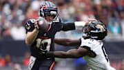 Nov 9, 2025; Houston, Texas, USA; Houston Texans quarterback Davis Mills (10) is pressured by Jacksonville Jaguars linebacker Devin Lloyd (0) during the first half at NRG Stadium. Mandatory Credit: Troy Taormina-Imagn Images