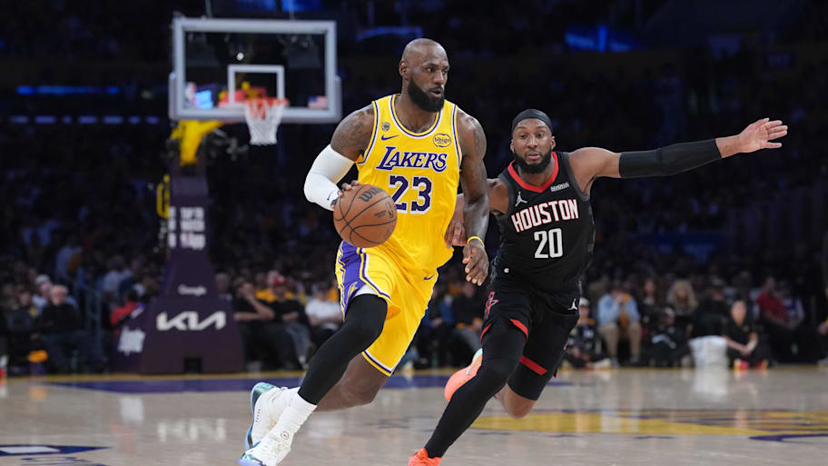 Lakers forward LeBron James drives to the basket against Rockets guard Josh Okogie.