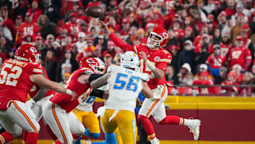 Dec 8, 2024; Kansas City, Missouri, USA; Kansas City Chiefs quarterback Patrick Mahomes (15) leaps while passing as Los Angeles Chargers defensive end Morgan Fox (56) defends during the second half at GEHA Field at Arrowhead Stadium. Mandatory Credit: Denny Medley-Imagn Images