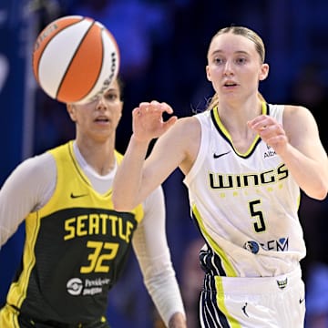 May 19, 2025; Arlington, Texas, USA;  Dallas Wings guard Paige Bueckers (5) receives a pass as Seattle Storm forward Alysha Clark (32) looks on during the second half at College Park Center. Mandatory Credit: Jerome Miron-Imagn Images