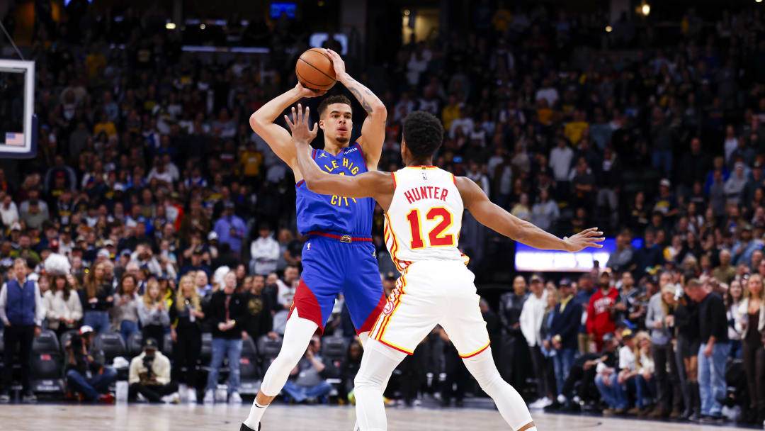 Apr 6, 2024; Denver, Colorado, USA; Denver Nuggets forward Michael Porter Jr. (1) looks to make a pass around Atlanta Hawks forward De'Andre Hunter (12) in the first half at Ball Arena. Mandatory Credit: Michael Ciaglo-USA TODAY Sports