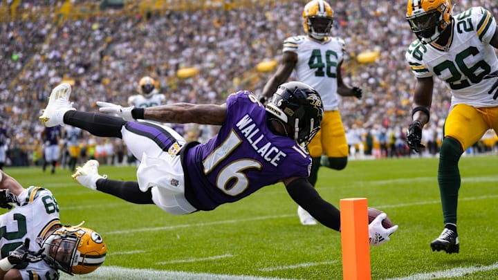 Aug 24, 2024; Green Bay, Wisconsin, USA;  Baltimore Ravens wide receiver Tylan Wallace (16) dives to score a touchdown as Green Bay Packers safety Zayne Anderson (39) defends during the second quarter at Lambeau Field. Mandatory Credit: Jeff Hanisch-Imagn Images