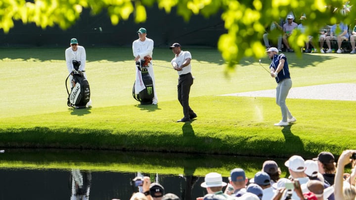 Apr 8, 2024; Augusta, Georgia, USA; Tiger Woods and Will Zalatoris skip the ball across the water at Augusta National during a practice round.