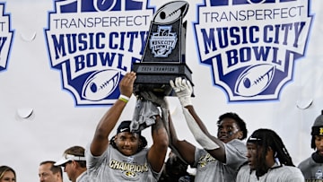 Several Missouri Tigers players hold up the TransPerfect Music City Bowl trophy, after a game versus the Iowa Hawkeyes last season.