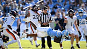 Oct 25, 2025; Chapel Hill, North Carolina, USA; North Carolina Tar Heels wide receiver Jordan Shipp (1) with the ball as Virginia Cavaliers safety Antonio Clary (0) and cornerback Emmanuel Karnley (19) and linebacker James Jackson (1) defend in the second quarer at Kenan Stadium. 