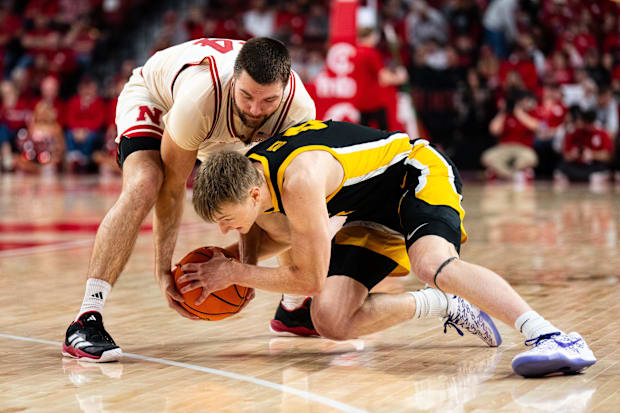 Nebraska Cornhuskers guard Rollie Worster (24) and Iowa Hawkeyes guard Josh Dix (4) fight for the ball