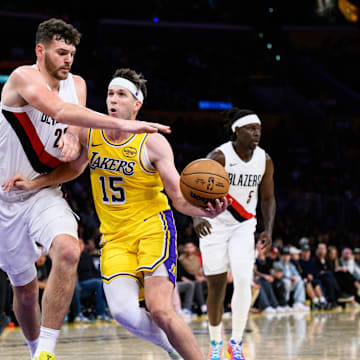 Oct 27, 2025; Los Angeles, California, USA; Los Angeles Lakers guard Austin Reaves (15) drives the ball under pressure from Portland Trail Blazers center Donovan Clingan (23) during the second half at Crypto.com Arena. Mandatory Credit: William Liang-Imagn Images