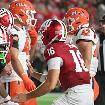 Indiana offensive lineman Pat Coogan (78) and quarterback Alberto Mendoza (15) celebrate with running back Khobie Martin.