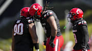 Oct 4, 2025; Cincinnati, Ohio, USA;  Cincinnati Bearcats defensive lineman Jalen Hunt (90), defensive end Mikah Coleman (4), and defensive back Jiquan Sanks (9) celebrate after a play against the Iowa State Cyclones in the first half at Nippert Stadium. Mandatory Credit: Aaron Doster-Imagn Images