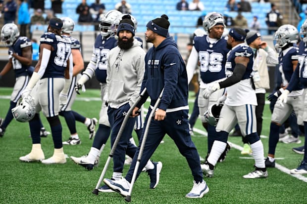 Dallas Cowboys quarterback Dak Prescott walks off the field with the team before the game at Bank of America Stadium.