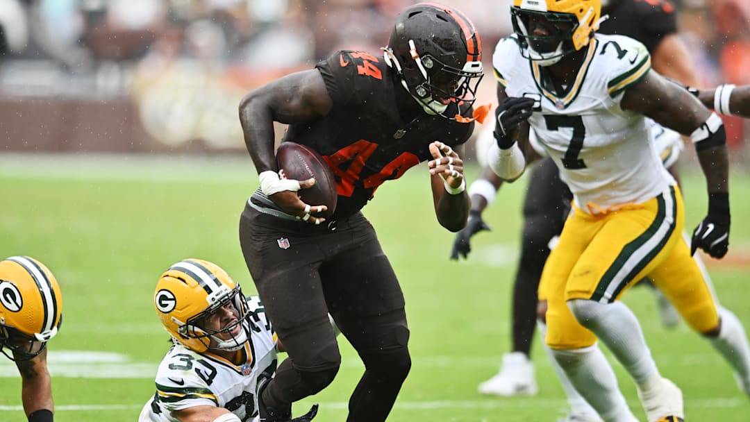 Sep 21, 2025; Cleveland, Ohio, USA; Green Bay Packers running back Emanuel Wilson (23) tries to tackle Cleveland Browns tight end Harold Fannin Jr. (44) during the second half at Huntington Bank Field. Mandatory Credit: Ken Blaze-Imagn Images