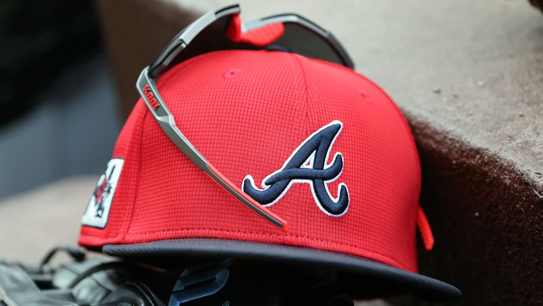 wMar 1, 2025; North Port, Florida, USA; A detail view of Atlanta Braves hat, sunglasses and glove in the dugout during the fifth inning at CoolToday Park. Mandatory Credit: Kim Klement Neitzel-Imagn Images