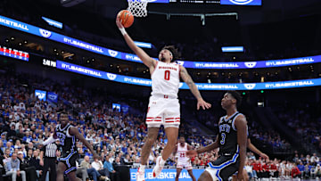Nov 21, 2025; Salt Lake City, Utah, USA; Wisconsin Badgers guard Braeden Carrington (0) lays the ball up against BYU Cougars forward AJ Dybantsa (3) during the first half at Delta Center. Mandatory Credit: Rob Gray-Imagn Images