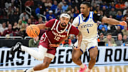 Mar 21, 2025; Milwaukee, WI, USA; Troy Trojans guard Tayton Conerway (12) drives to the hoop past Kentucky Wildcats guard Lamont Butler (1) during the second half at Fiserv Forum. Mandatory Credit: Benny Sieu-Imagn Images