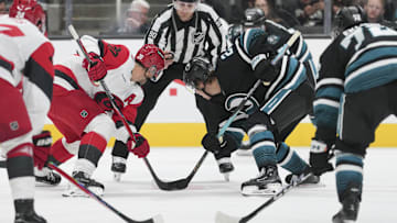Oct 14, 2025; San Jose, California, USA;  Carolina Hurricanes center Sebastian Aho (20) and San Jose Sharks center Will Smith (2) face off during the third period at SAP Center at San Jose. Mandatory Credit: Stan Szeto-Imagn Images
