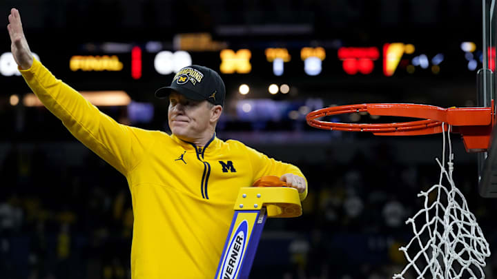 Michigan Wolverines head coach Dusty May cuts a piece of net Monday, April 6, 2026, while celebrating the team’s NCAA men's basketball tournament national championship victory over the UConn Huskies 69-63 at Lucas Oil Stadium in Indianapolis.