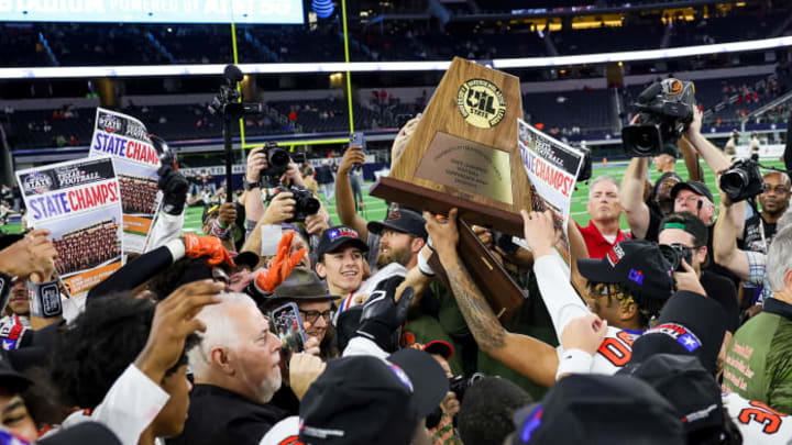 Gilmer players hold the trophy after winning the 2023 UIL 4A Division II title at AT&T Stadium in Arlington, Texas.