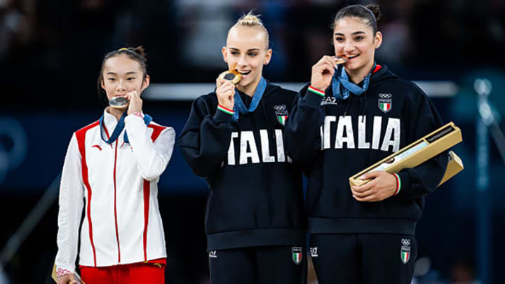 Yaqin Zhou of Team China stands next to Italians Alice D'Amato and Manila Esposito on the podium during the medal ceremony for the balance beam final.