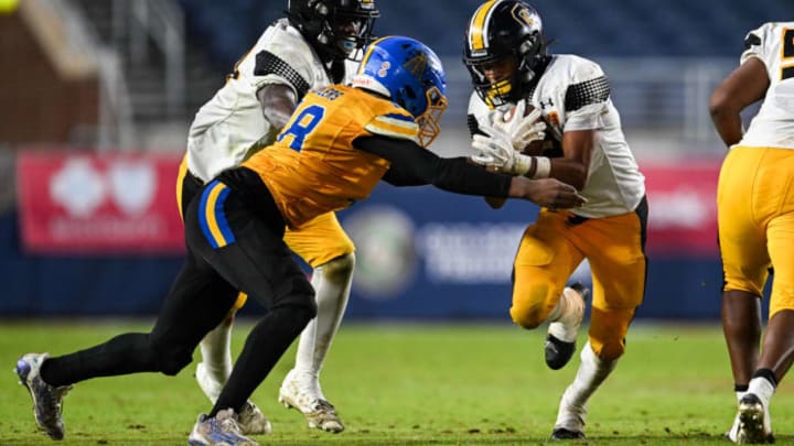 Charleston tailback Marcus Flowers runs the ball against the Heidelberg defense at the MHSAA Class 2A State Championship game at Oxford's Vaught-Hemingway Stadium.