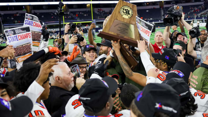 Gilmer players hold the trophy after winning the 2023 UIL 4A Division II title at AT&T Stadium in Arlington, Texas.