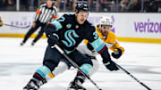 Nov 20, 2024; Seattle, Washington, USA;  Seattle Kraken forward Yanni Gourde (37) skates against Nashville Predators forward Tommy Novak (82) during the first period at Climate Pledge Arena. Mandatory Credit: Stephen Brashear-Imagn Images