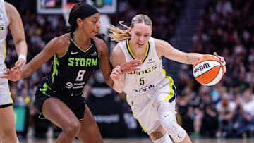 Jul 22, 2025; Seattle, Washington, USA;  Dallas Wings guard Paige Bueckers (5) dribbles the ball against Seattle Storm guard Lexie Brown (8) during the second half at Climate Pledge Arena. Mandatory Credit: Stephen Brashear-Imagn Images
