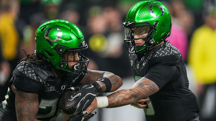 Oregon Ducks quarterback Dillon Gabriel (8) hands off the ball to Oregon Ducks running back Jordan James (20) Oregon Ducks quarterback Dillon Gabriel (8) hands off the ball to Oregon Ducks running back Jordan James (20)