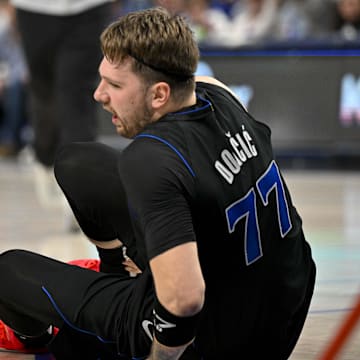 Feb 3, 2024; Dallas, Texas, USA; Dallas Mavericks guard Luka Doncic (77) appears to suffer a leg injury as he battles for the loose ball with Milwaukee Bucks forward Giannis Antetokounmpo (34) during the first quarter at the American Airlines Center. Mandatory Credit: Jerome Miron-Imagn Images