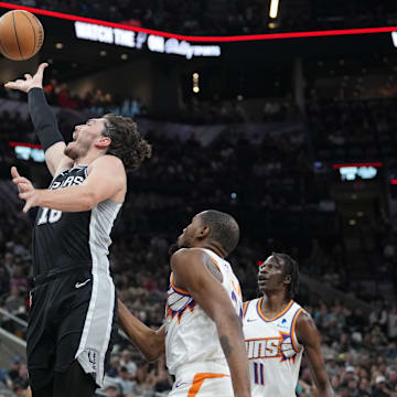 Mar 23, 2024; San Antonio, Texas, USA;  San Antonio Spurs forward Cedi Osman (16) shoots over Phoenix Suns guard Bradley Beal (3) in the first half at Frost Bank Center. Mandatory Credit: Daniel Dunn-Imagn Images