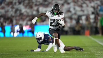 Sep 27, 2025; University Park, Pennsylvania, USA; Oregon Ducks running back Dierre Hill Jr. (23) runs for a gain after breaking a tackle by Penn State Nittany Lions cornerback Zion Tracy (7) during the third quarter at Beaver Stadium. Mandatory Credit: James Lang-Imagn Images