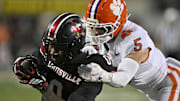 Nov 14, 2025; Louisville, Kentucky, USA;  Louisville Cardinals wide receiver Chris Bell (0) runs the ball against Clemson Tigers safety Ronan Hanafin (5) during the first half at L&N Federal Credit Union Stadium. Mandatory Credit: Jamie Rhodes-Imagn Images