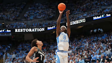 Dec 7, 2025; Chapel Hill, North Carolina, USA;  North Carolina Tar Heels forward Caleb Wilson (8) shoots as Georgetown Hoyas forward Isaiah Abraham (7) defends in the second half at Dean E. Smith Center. Mandatory Credit: Bob Donnan-Imagn Images