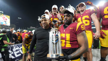 Dec 27, 2023; San Diego, CA, USA; Southern California Trojans director of player development Chris Carter (left) and defensive end Solomon Byrd (51) hold the Holiday Bowl championship trophy at Petco Park. Mandatory Credit: Kirby Lee-USA TODAY Sports