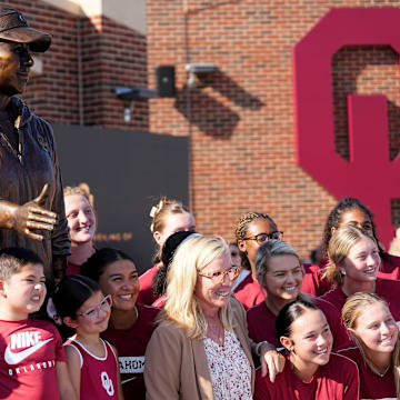 Oklahoma head coach Patty Gasso take a picture with players and family during a statue dedication at Love's Field in Norman, Okla,, Friday, Sept., 13, 2024.