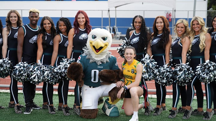 Sep 4, 2024; Sao Paolo, Brazil; IFAF and NFL Global flag football ambassador Gabi Bankhardt of Brazil poses with Philadelphia Eagles cheerleaders and mascot Swoop at community day at Clube Recreativo 